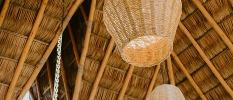 Una estructura de techo de paja con lámparas colgantes tejidas.