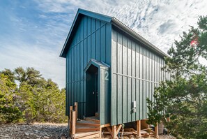 A single-story building with a sloped roof, a small porch, and a door marked with the number 2. - Blue Sage No. 12 - The Long Loft Hideaway (Fredericksburg)