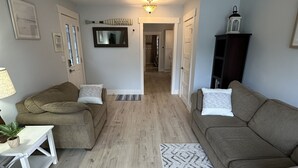 Ein Wohnzimmer mit zwei Sofas, einem Couchtisch und einem gemusterten Teppich.