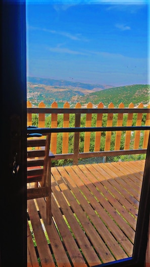 Una terraza de madera con vistas a un paisaje montañoso.