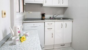A modern kitchen with white cabinets, a countertop, and a dishwasher. - Beautiful apartment for 4 guests with pool, WIFI, A/C, TV and pets allowed (Benidorm)