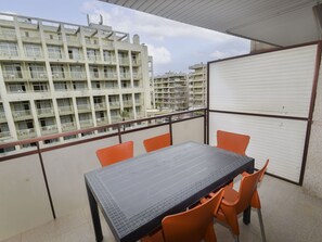 A balcony with a table and chairs, overlooking a residential building. - Beautiful apartment for 4 guests with WIFI, A/C, pool, TV and terrace (Salou)