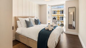 A bedroom with a bed, bedside table, and a view of the outside. - Apartment 295 - Clifden - sleeps 5 guests  in 2 bedrooms (Clifden)