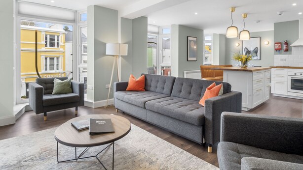 A spacious living area with a grey sofa, a coffee table, and a floor lamp. - Apartment 295 - Clifden - sleeps 5 guests  in 2 bedrooms (Clifden)