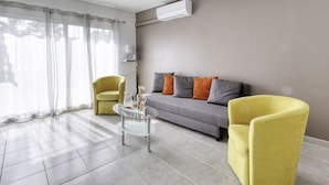 A modern living room with a grey sofa, yellow armchairs, and a glass coffee table. - bonnegrace by Interhome (Six Fours)