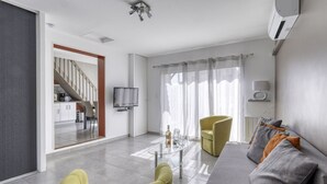A modern living room with a sofa, yellow armchair, and a glass coffee table. - bonnegrace by Interhome (Six Fours)