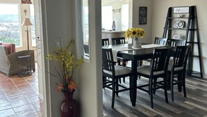 A dining area with a table and chairs, a vase with flowers, and a view of the outdoors. - A retreat near Elephant Butte Lake with awesome views. Don’t miss out. Enjoy! (Elephant Butte)