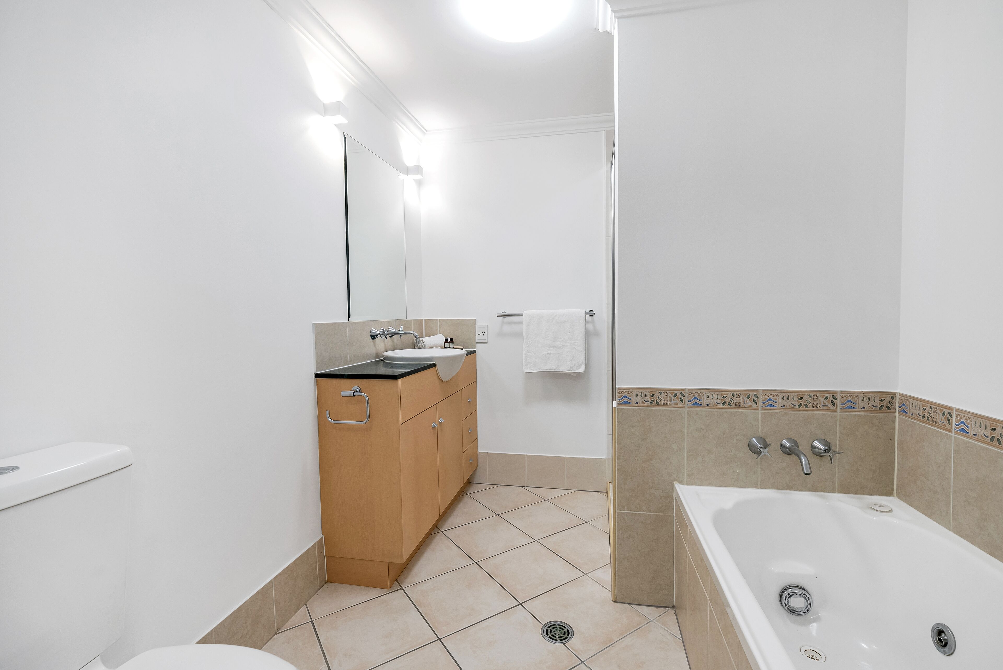 Ein modernes Badezimmer mit Toilette, Waschbecken, Waschtisch und Badewanne.