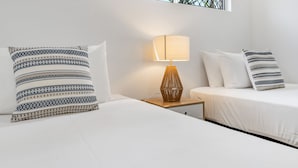 Ein Hotelzimmer mit zwei Betten, einer Nachttischlampe und einem Wandbild.