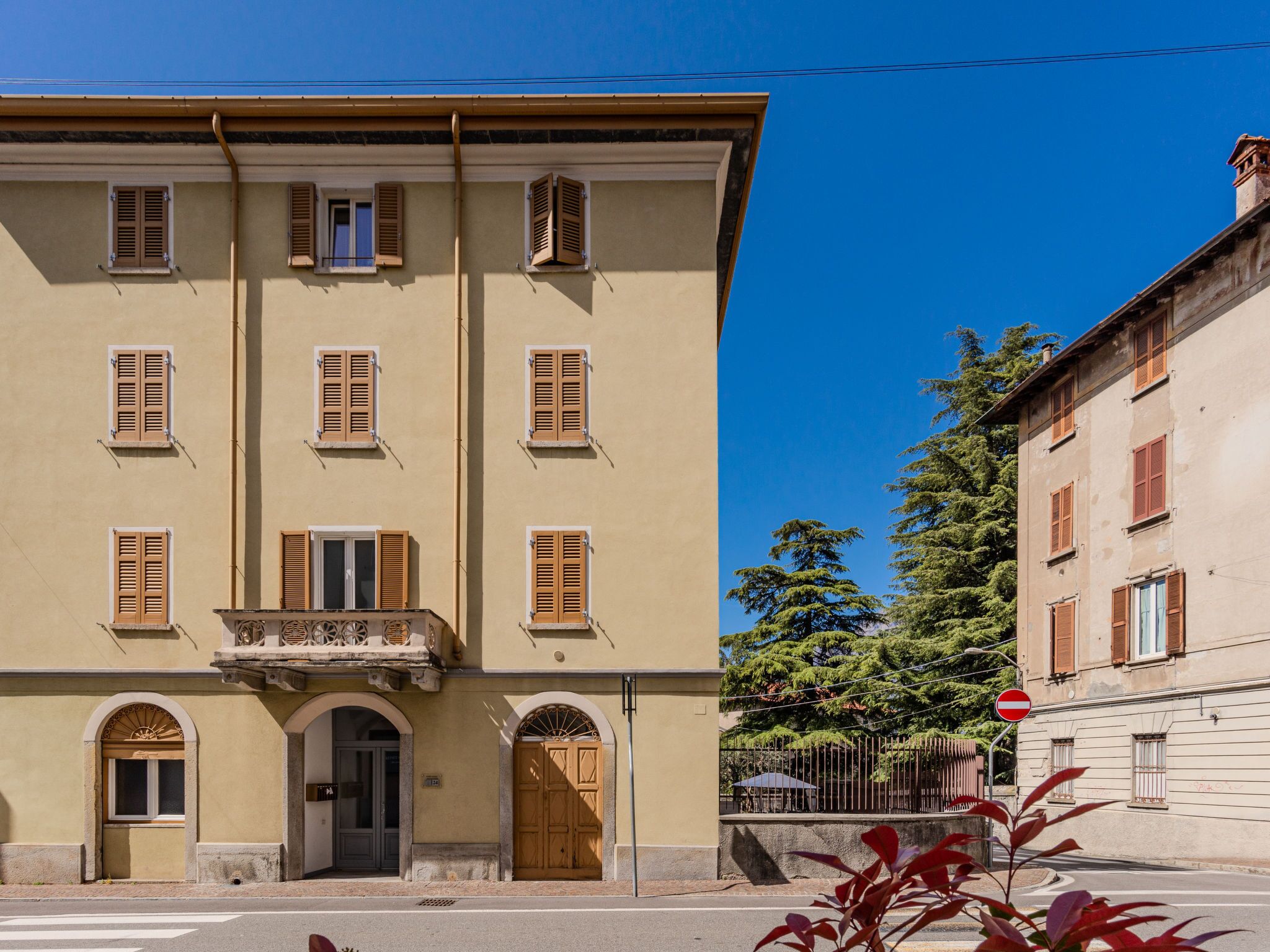 Un bâtiment doté de nombreuses fenêtres, d’une entrée centrale avec une porte et d’un petit balcon.