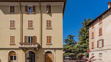 Un bâtiment doté de nombreuses fenêtres, d’une entrée centrale avec une porte et d’un petit balcon.