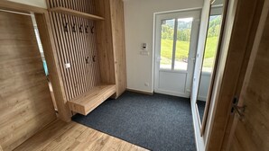 A room with a wooden slatted partition, a black carpet, a door leading outside, and a visible outdoor view. - 13ka Ground Oasis with Terrace by Interhome (Smržovka)