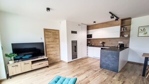 A modern kitchen with white cabinets, a wooden countertop, and a built-in microwave. - 13ka Ground Oasis with Terrace by Interhome (Smržovka)