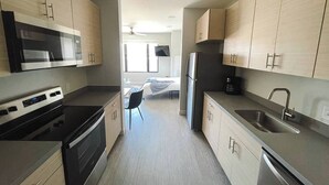 A modern kitchen with stainless steel appliances, wooden cabinets, and a central island.