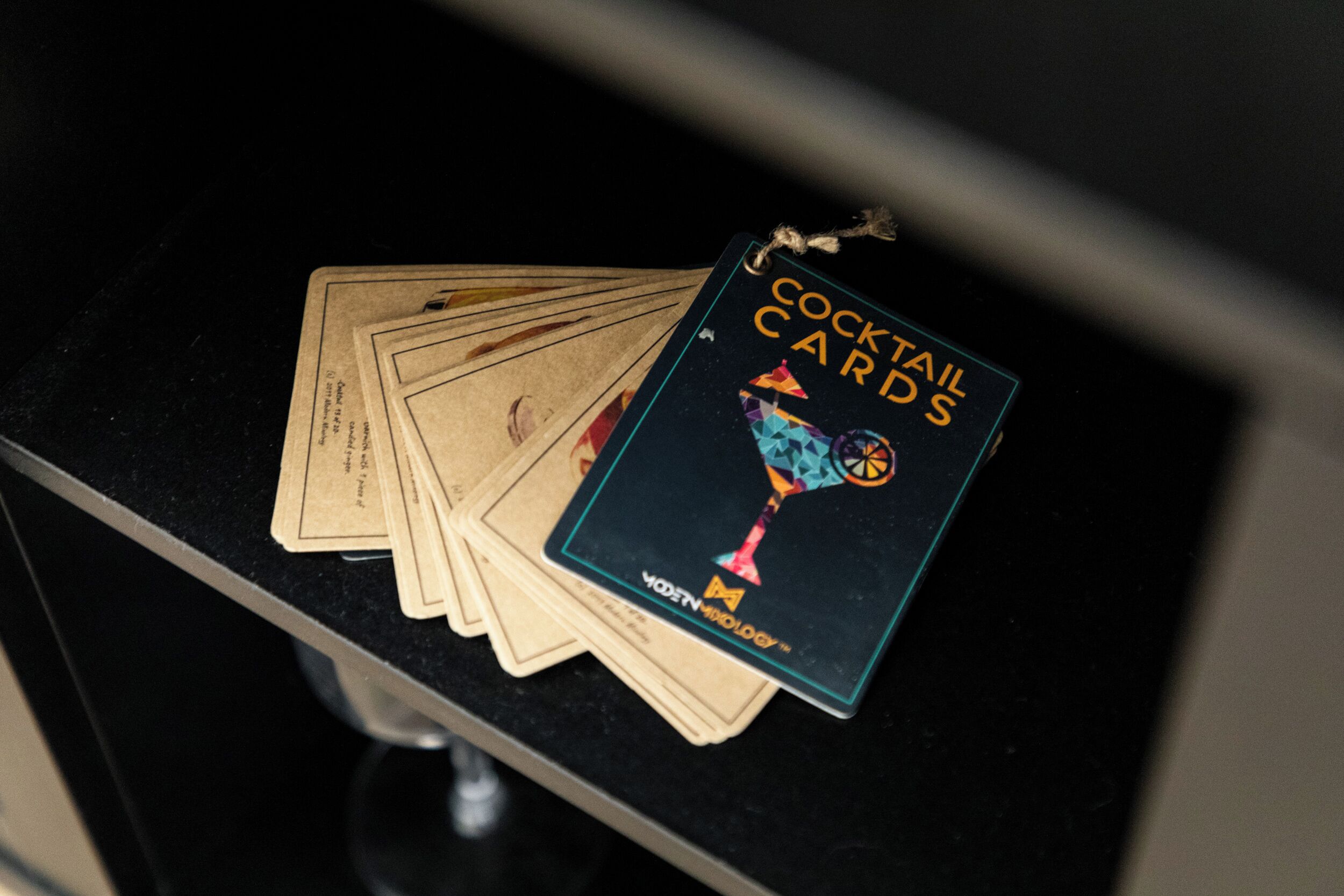 Un ensemble de cartes de cocktails posé sur un comptoir noir.