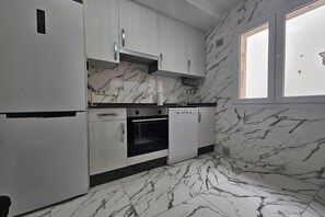 A kitchen with white cabinets, a black oven, and a dishwasher.