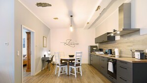 A modern kitchen with a dining table, chairs, and a built-in oven.