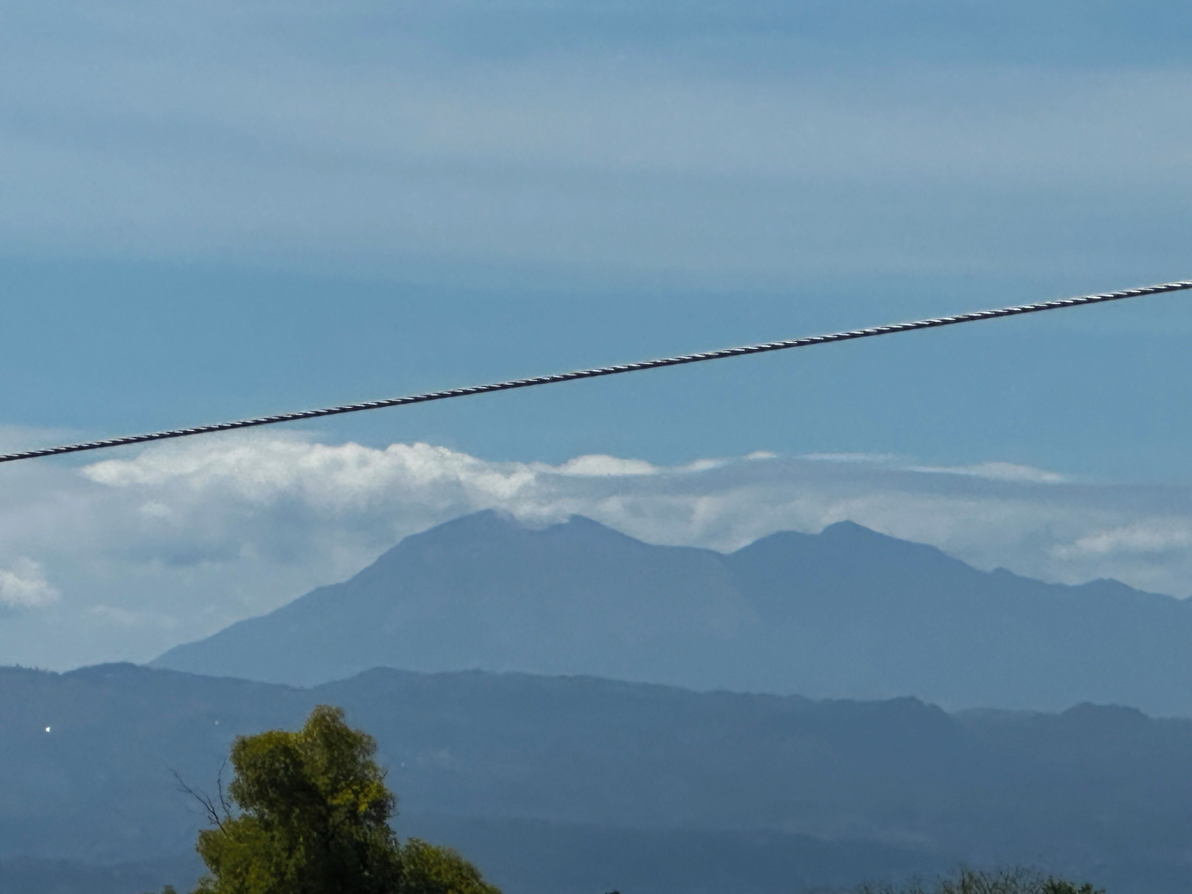 A mountain range with a power line in the foreground.