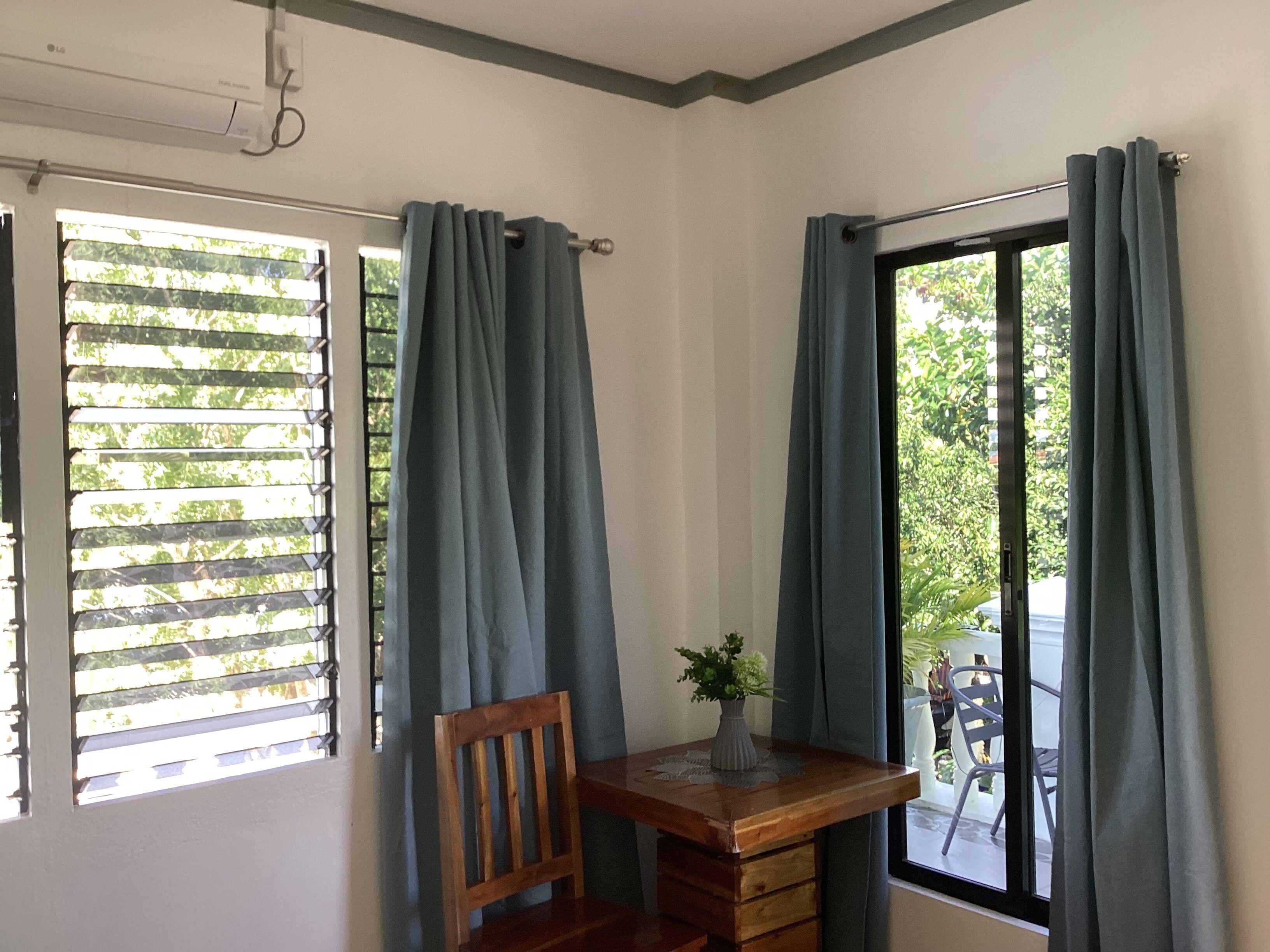 A room with a wooden desk, a chair, and a window with curtains.