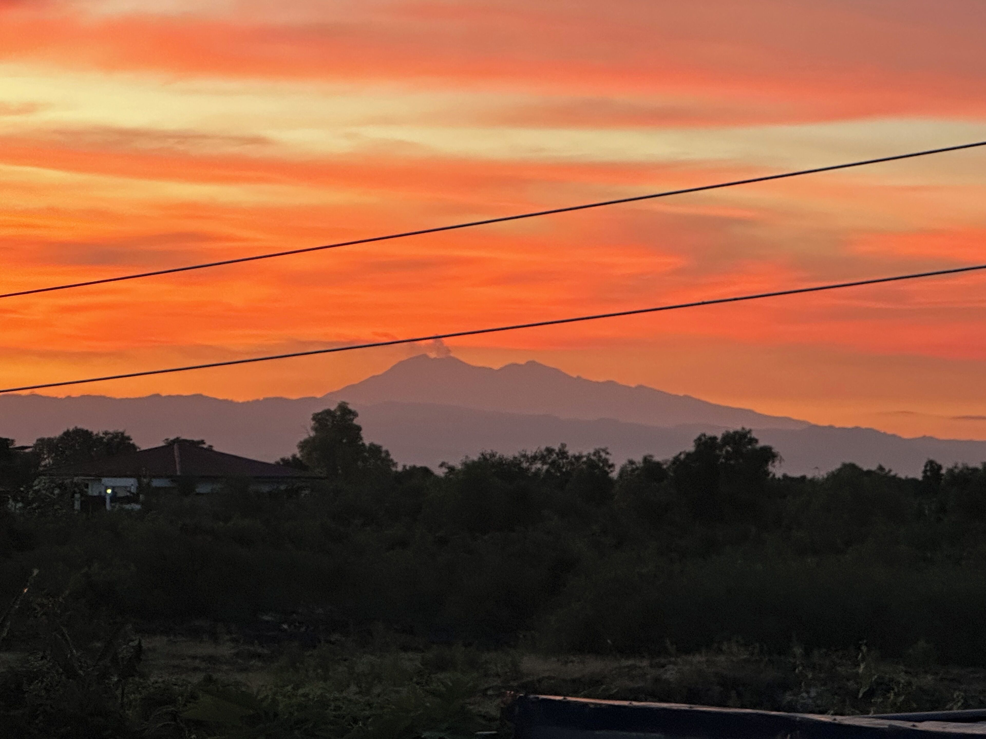 Et bjerglandskab i solnedgang med en klar himmel.