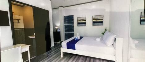 Un dormitorio moderno con cama, escritorio y ventilador de techo.