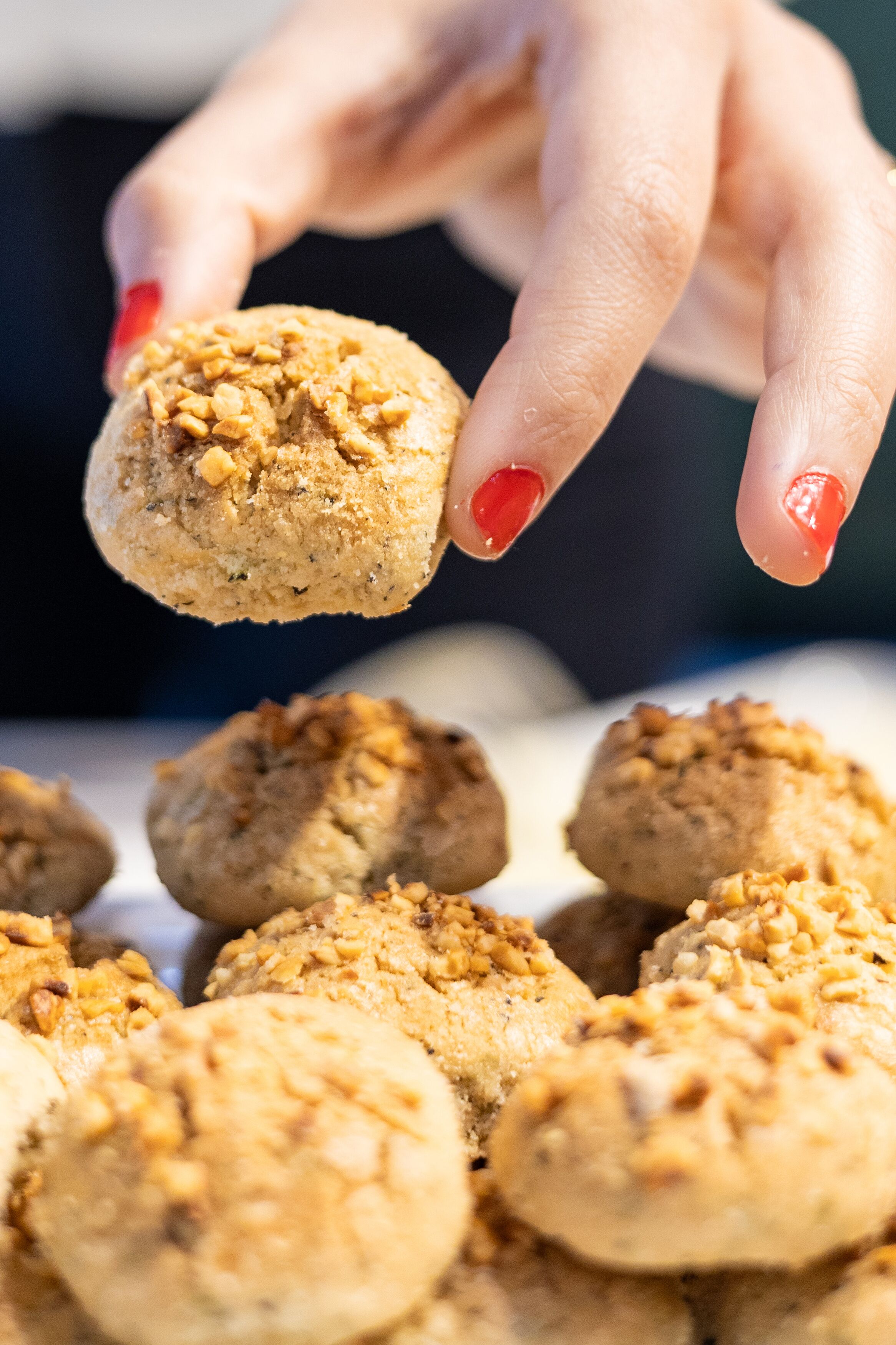 A hand holding a cookie with visible nuts.