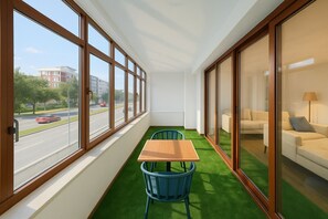A room with a table and chairs, large windows, a green carpet, and a sofa. - Niva Atakum Otel (Atakum)
