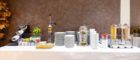 A buffet setup with various food items and utensils.
