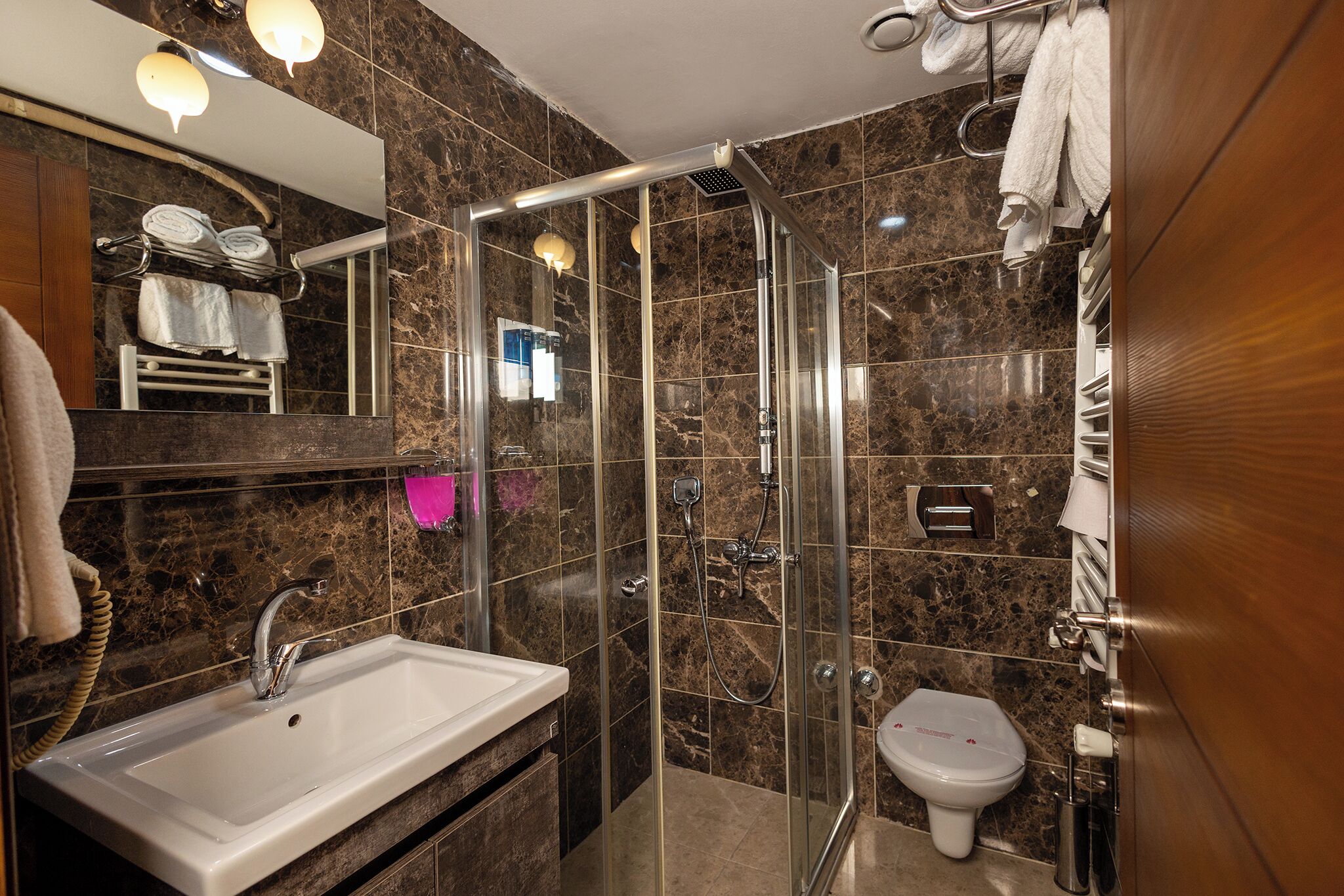 Un baño moderno con ducha de vidrio, lavamanos y retrete.