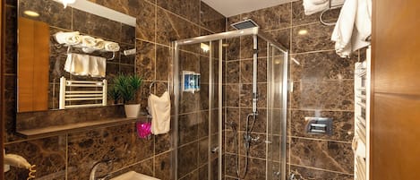 Een moderne badkamer met een douchecabine van glas, een wastafel en een toilet.