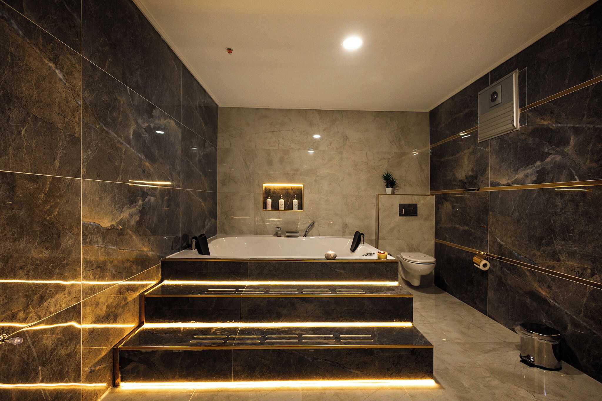 Une salle de bain moderne avec une grande baignoire, des toilettes et un lavabo.