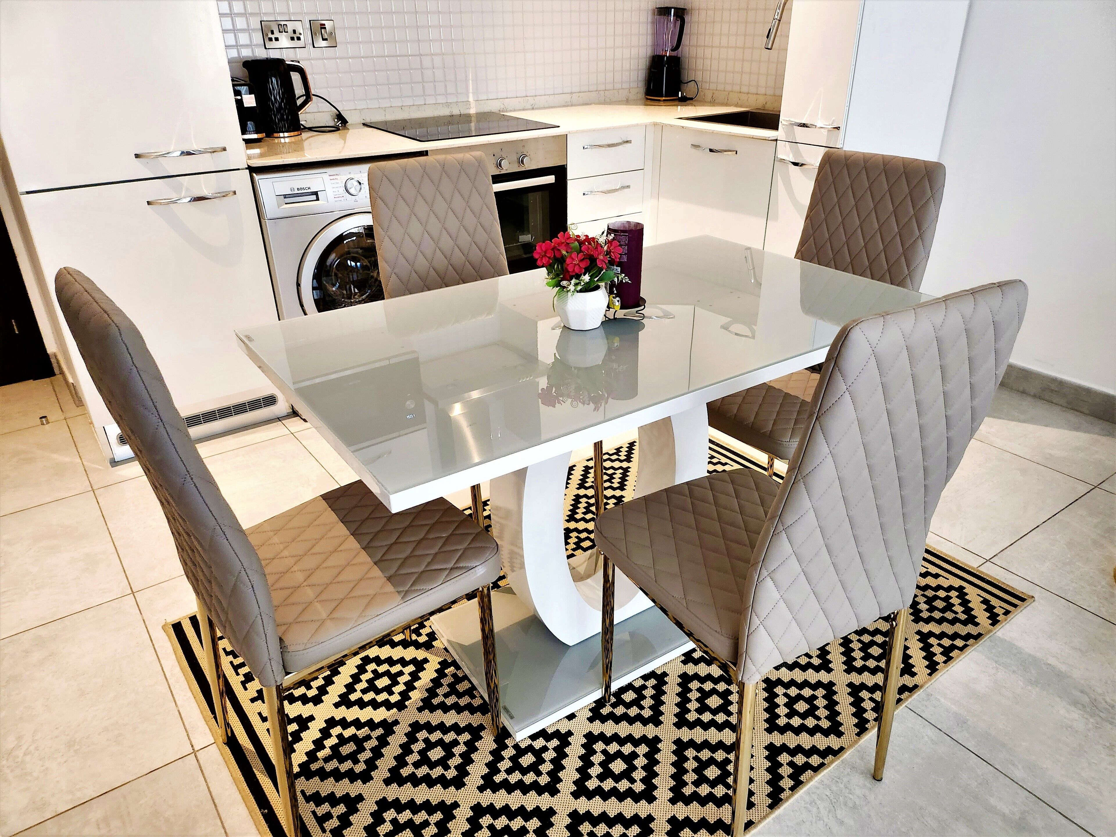 A modern kitchen with a Bosch washing machine, a coffee maker, and a dishwasher.