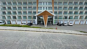 Un moderno edificio de hotel con una fachada geométrica llamativa y una entrada central.