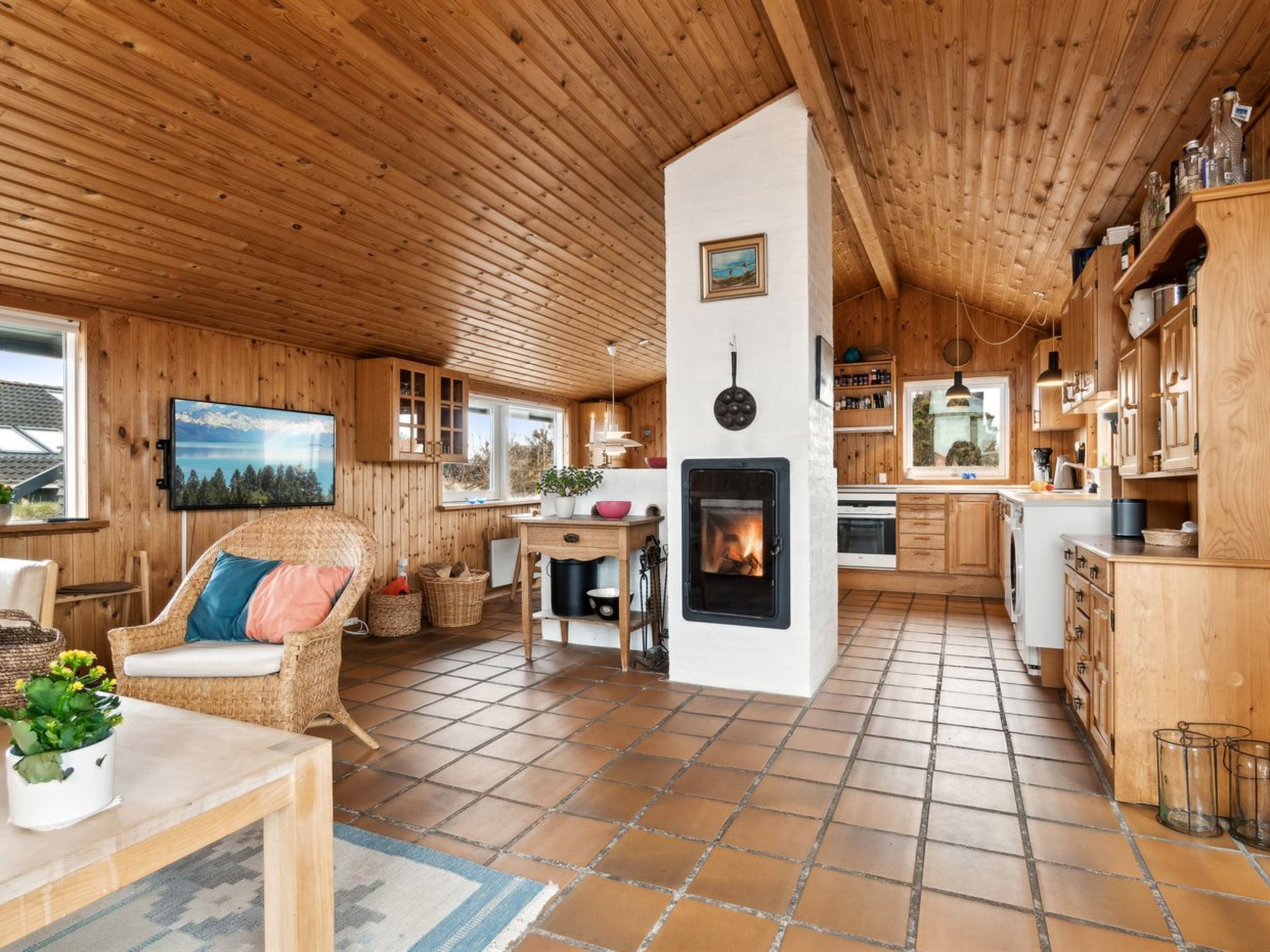 Ein gemütliches Blockhaus-Interieur mit Kamin, Holzwänden und einem Essbereich.