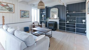 Una sala de estar con sofá, mesa de centro, chimenea y estanterías.