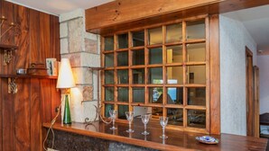 Une cuisine dotée d’un plan de travail en bois, d’un pare-feu en pierre et d’une fenêtre à carreaux multiples.