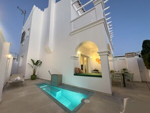 A modern building with a swimming pool, outdoor seating, and a view of the sky. - Nerja Paradise Rentals - Villa Coral (Nerja)