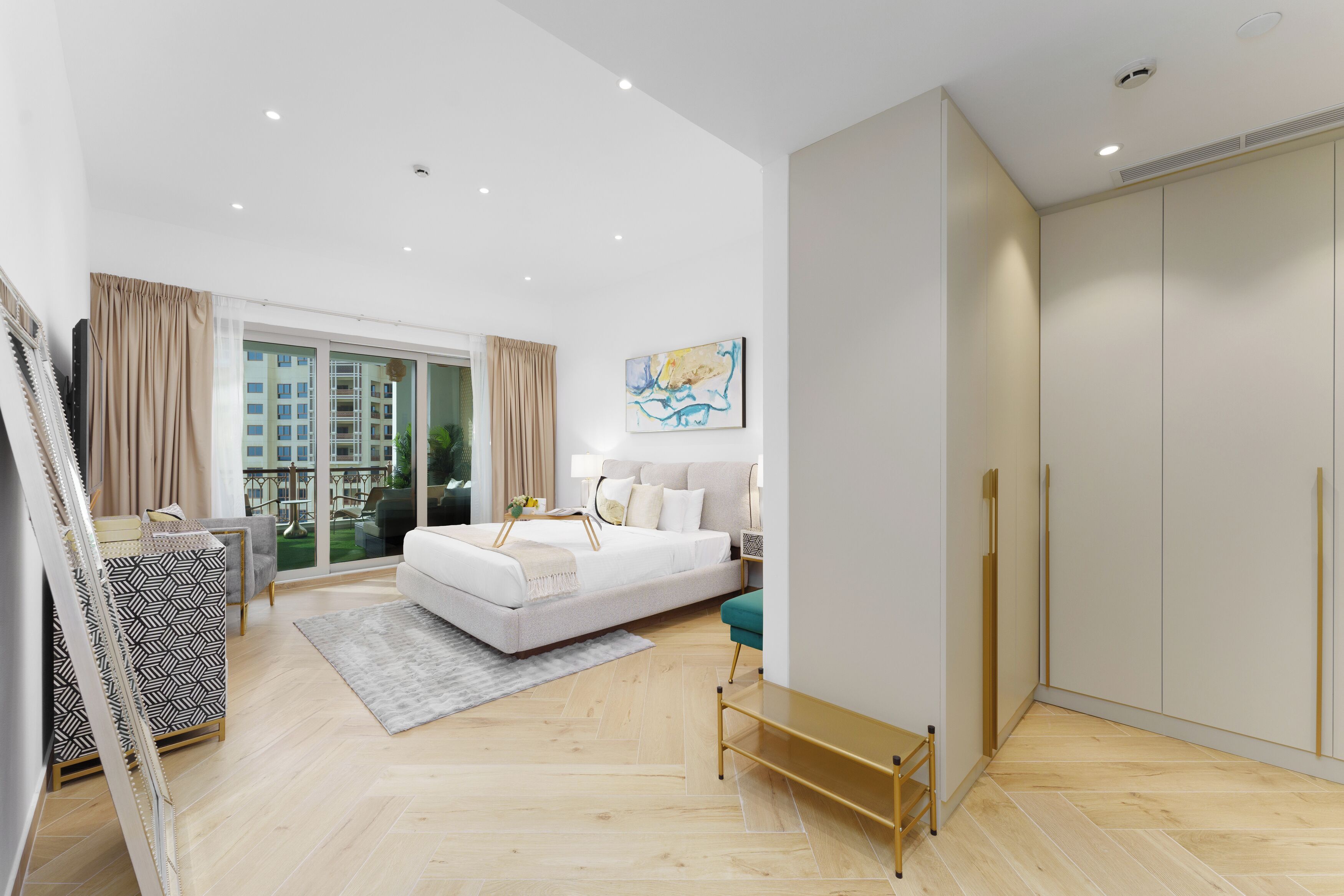 Ein modernes Schlafzimmer mit einem großen Bett, einem Kleiderschrank und Blick auf die Stadt durch eine Glasdoor.
