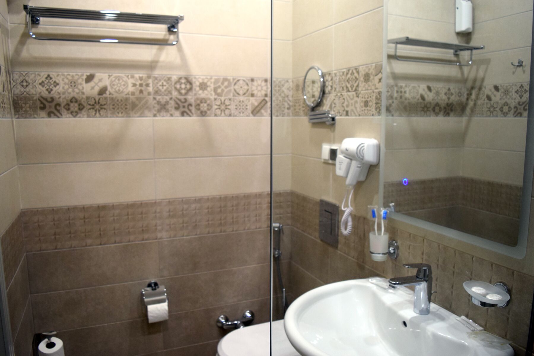 A bathroom with a glass shower enclosure, a sink with a mirror, and a towel rack.