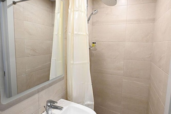 Economy eenpersoonskamer | Badkamer | Een douche, een regendouche, een haardroger, badjassen