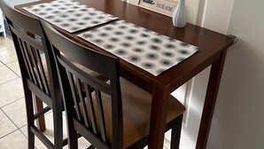 A dining table with a placemat, chairs, a wall-mounted artwork, and a sign saying "You're Home".