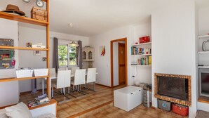 Ein modernes Wohnzimmer mit Kamin, Essbereich und Küche.