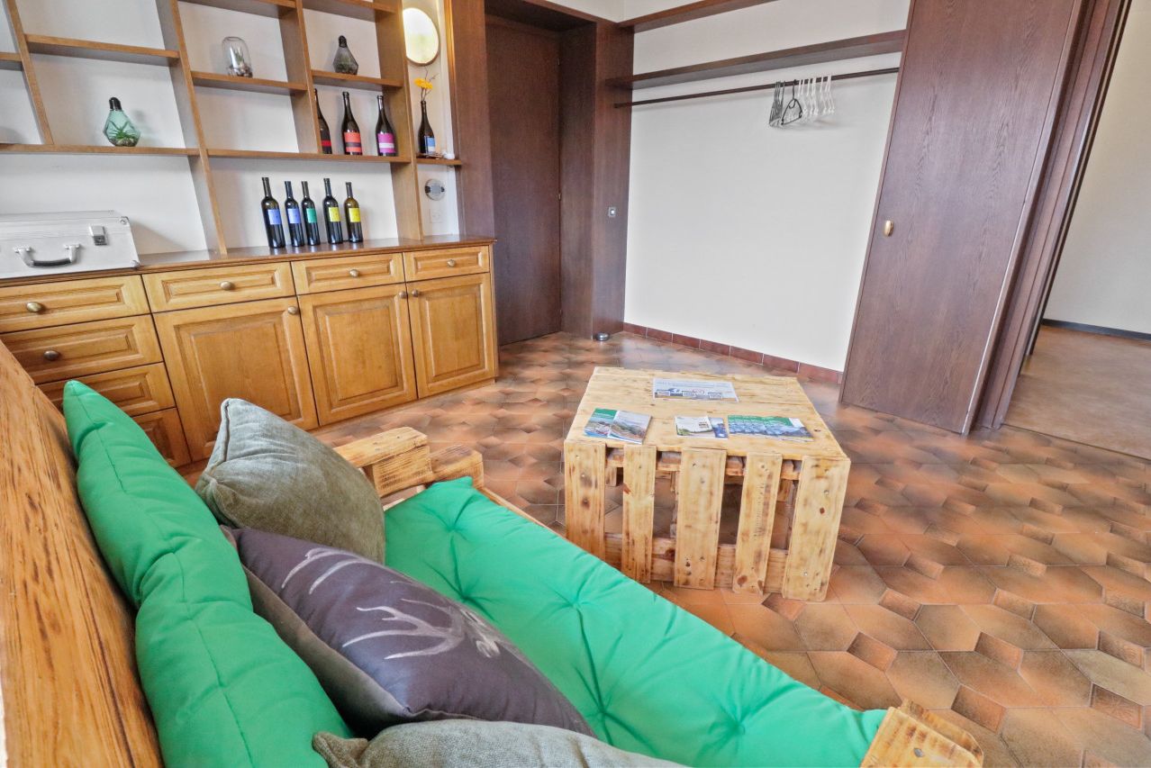 Un accogliente angolo living con un divano verde, mobili in legno e un tavolino da caffè in legno.
