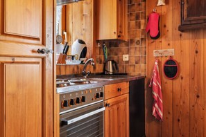 A kitchen with wooden cabinets, a stainless steel stove, and a sink.