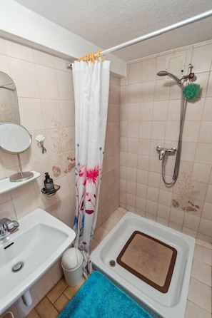 A bathroom with a shower, a sink, and a bathtub.