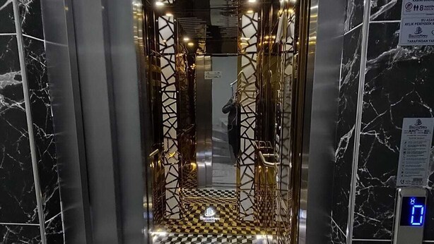 An elevator with a checkered floor and metallic walls. - Trabzon White Life (Trabzon)