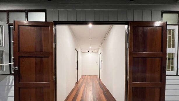 Käytävä, jossa on puiset ovet ja tervetulomat eteisessä.