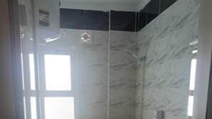 A bathroom with a toilet, a shower, a sink, and a scale. - MADEII project training center hostel (Al-'Amriyah)