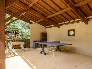 An indoor recreational area with a ping pong table, a foosball table, and a billiards table.
