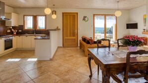 Une cuisine spacieuse dotée d’un îlot central, de meubles en bois et d’un coin repas avec une table et des chaises.